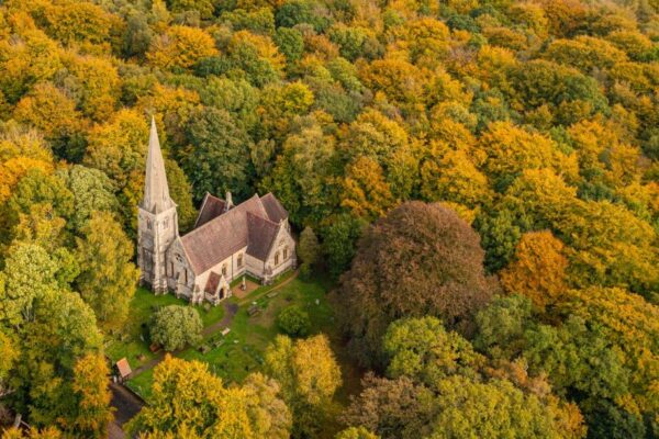 Aerial view from a drone of the Holy Innocents Church in Epping Forest, Essex, UK. This photo was captured in the height of Autumn in October 2022.