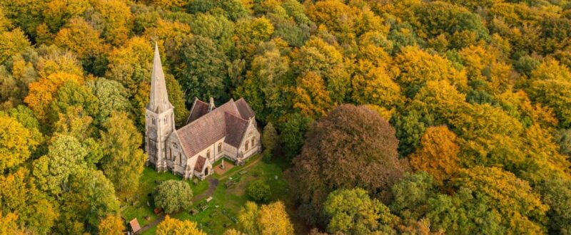 Aerial view from a drone of the Holy Innocents Church in Epping Forest, Essex, UK. This photo was captured in the height of Autumn in October 2022.