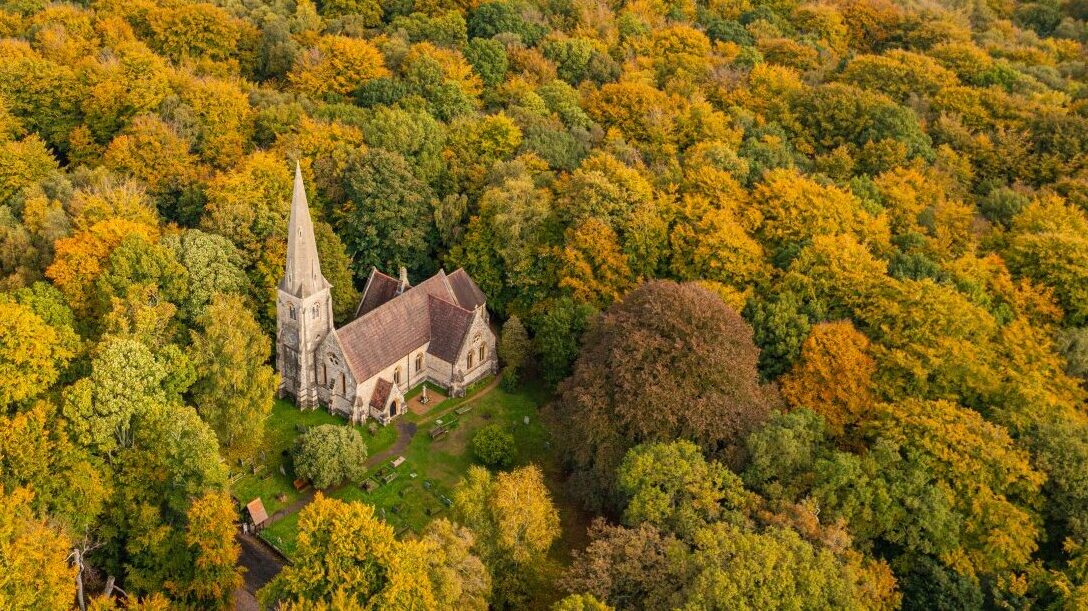 Aerial view from a drone of the Holy Innocents Church in Epping Forest, Essex, UK. This photo was captured in the height of Autumn in October 2022.