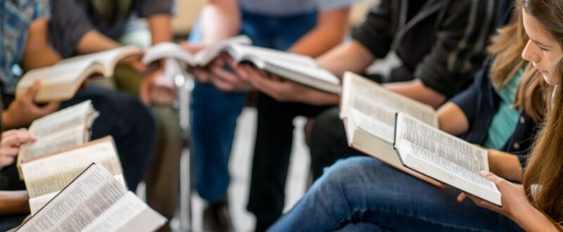 A group of high school students studying the Bible together.