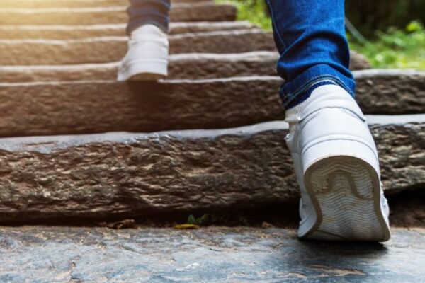 Young woman's trainers climbing stone steps