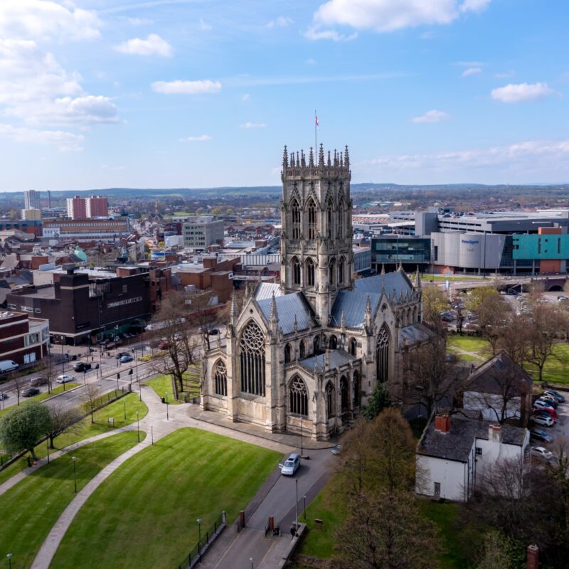 Doncaster, UK - April 15, 2022. An aerial landscape view of The Minster Church of St George in a Doncaster town centre cityscape with the Frenchgate centre shopping mall