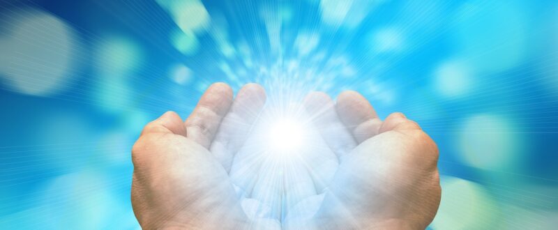 A close-up of hands holding a bright light