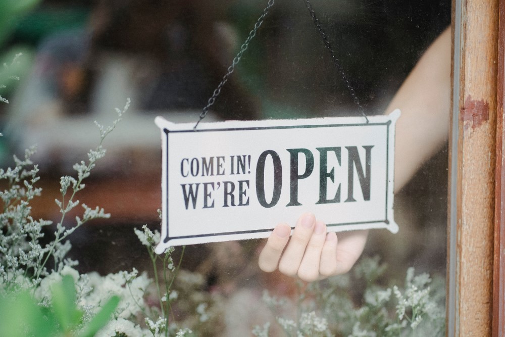 Sign in shop window that reads Come in! We are OPEN
