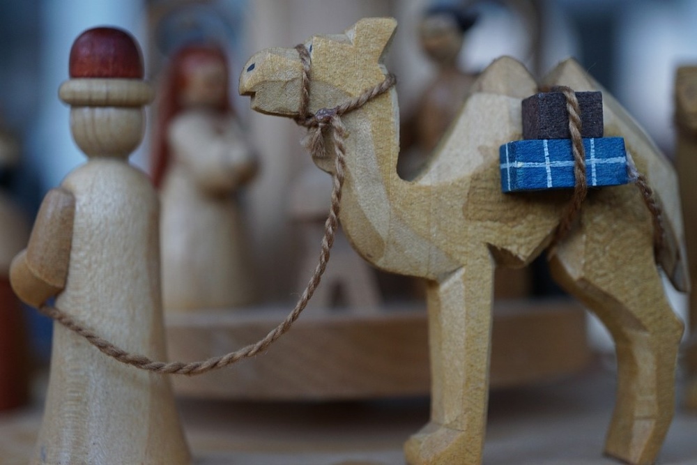 wooden figure of a man leading a camel