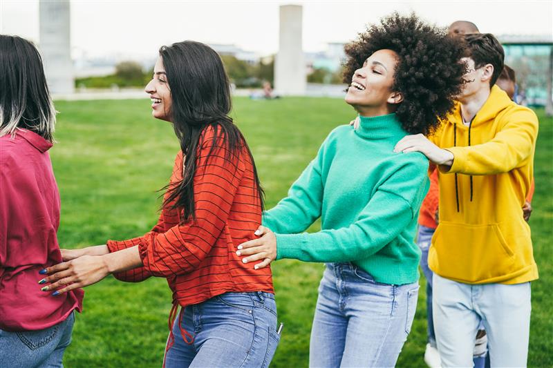 young diverse people dancing in conga line